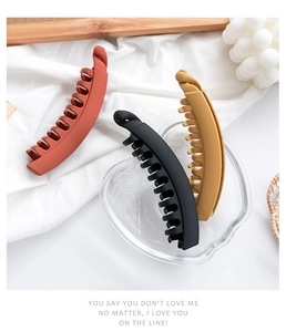 Detail of matte banana hair clips in black, yellow and brown with multi-teeth grip