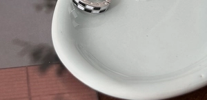 Détail de créoles en émail à damier avec contraste noir et blanc sur métal argenté