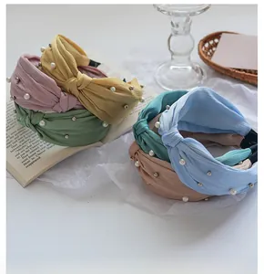 Detail view of twisted knotted headbands with elegant pearls and silver beads decoration