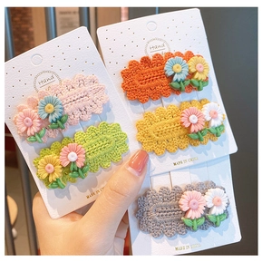 Detailed macro view of handmade crochet daisy flower hair clips in various macaron colors