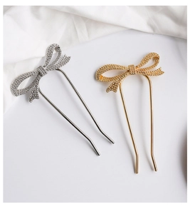 Detail of gold and silver U-shaped metal hairpins with elegant frosted bow design