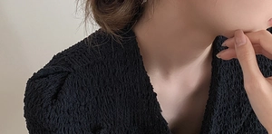 Vue détaillée du tissu plissé noir avec texture gaufrée et motif à bulles unique