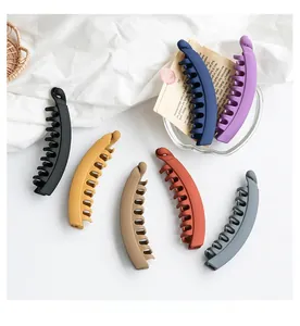 Detailed collection of 7 matte banana hair clips in various dark colors on fabric