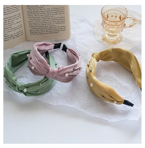 Close-up of pleated fabric headbands with elegant pearl beads and non-slip ends