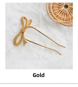 Detail of a textured gold bow hair fork with a minimalist U-shaped metal pin design