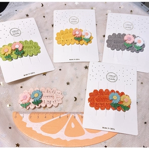 Detailed macro view of 5 handmade crochet flower hair clips on a white display card