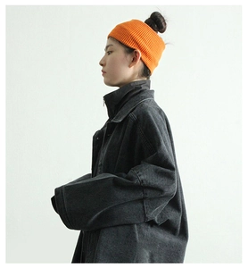 Close-up of bright orange ribbed knit headband paired with a vintage denim jacket