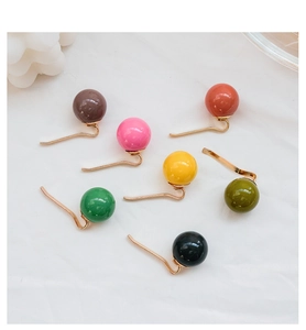 Macro detail of seven colorful glossy beads on gold-tone hair hooks for ponytail styles