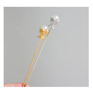 Détail macro d'épingles à cheveux or et argent avec grandes perles et pierres de zircone