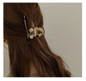 Close-up of tortoise shell pattern acetate hair claw clip worn on long brunette hair