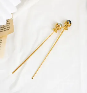 Détail d'épingles à cheveux dorées avec perles grises sur papier rétro élégant