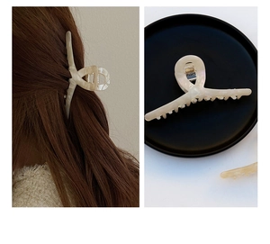 Detailed view of large marbled cream acetate hair claw clip with strong metal spring