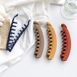 Matte finish banana hair clips in four deep colors on white fabric background