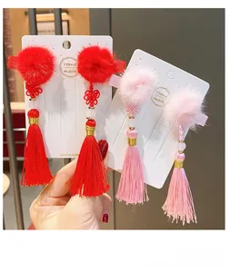 Détail de pinces à cheveux de style chinois faites à la main avec boules de poils et pompons