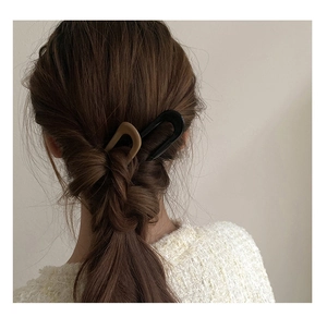 U-shaped hair pins in black and matte beige shown on a woman for a chic updo hairstyle