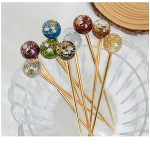 Détail d'épingles à cheveux sphériques étoilées avec feuilles d'or en bol de verre