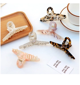Detailed top view of assorted tortoiseshell and marble acetate hair claws on a white desk