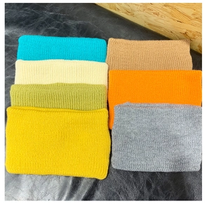 Flat lay of colorful knitted headbands in seven vibrant shades with soft texture details
