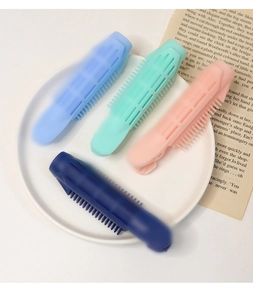 Nahaufnahme von vier bunten Volumen-Haarclips in einer dekorativen Keramikschale