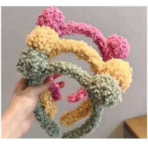 Detailed plush texture of colorful lamb wool bear ear headbands in pink, yellow, and green