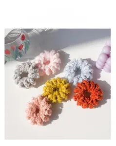 Dettaglio di elastici per capelli a spirale in peluche in sei colori su base bianca