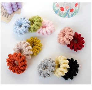 Dettaglio dall'alto di un set di elastici per capelli in peluche colorati su sfondo bianco