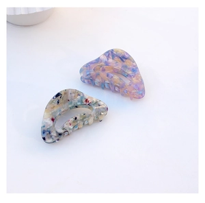 Detail view of large marbled acetate hair claws with premium glossy polished texture