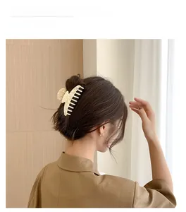 Detail of elegant acetate hair claw clip with marble texture on long hair