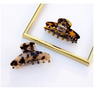 Detail of tortoise shell acetate hair claws with gold springs in dark and light tones