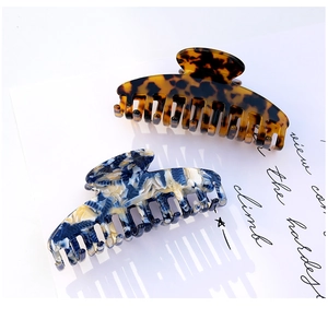Close-up of large acetate hair claws with elegant tortoiseshell and marble patterns