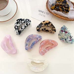 Elegant large acetate hair claws in various patterns like marble, tortoise and pastel colors