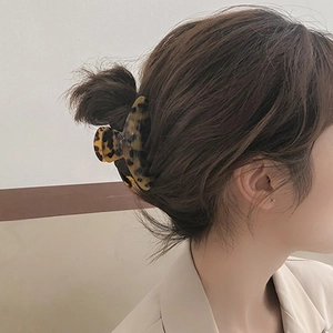 Medium acetate triangle hair claw clip in tortoiseshell pattern worn on a half ponytail