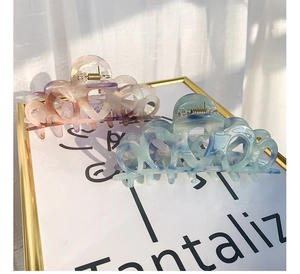 Detail of marble pattern acetate claw clips in heart shape with purple and blue gradients