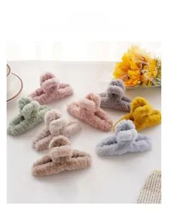 Close-up of assorted plush faux fur hair claw clips in various pastel colors on a desk