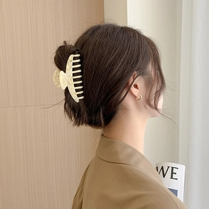 Elegant beige marble acetate hair claw clip for women styled on brown wavy hair