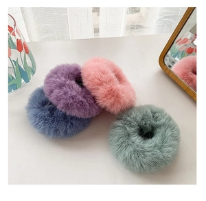 Detailed macro view of four plush faux mink fur hair ties in soft macaron pastel colors