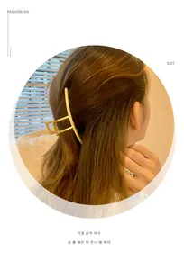 Minimalistische matte goldene geometrische Haarklammer an Modell mit langem Haar