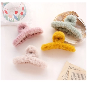 Set of colorful plush hair claws in pink, beige, yellow and green on a minimalist background