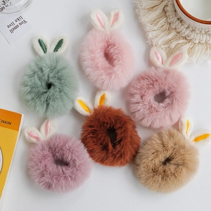 Cute plush rabbit ear hair scrunchies in six pastel colors on a white tabletop