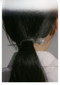 Minimalist silver metal hair pin with translucent grey-purple bead detail worn on a ponytail