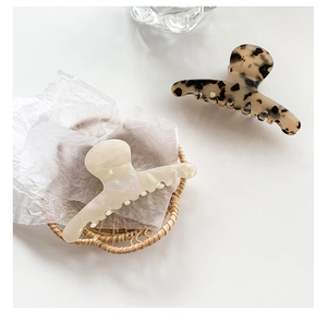 Detail of large acetate hair claws in cream pearl and tortoise shell patterns