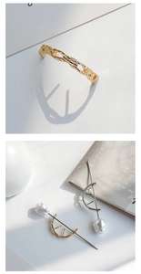 Detail of minimalist golden lava texture cuff and baroque pearl hair pins on white backdrop