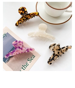 Close-up of four elegant acetate hair claws in marble and leopard patterns