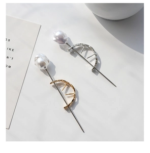 Detail view of baroque pearl hair sticks with textured gold and silver metal frames