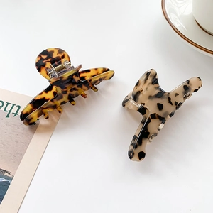 Elegant tortoiseshell acetate claw clips in dark leopard and light patterns with metal spring