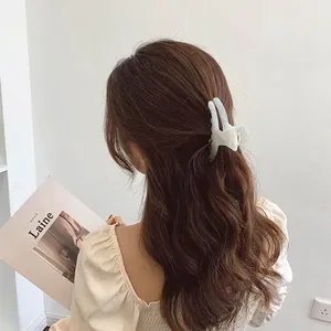 Elegant large beige marble acetate hair claw clip for a French minimalist updo hairstyle