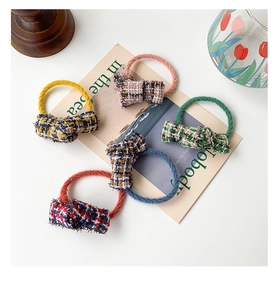 Set of five elegant tweed bow hair ties in assorted colors on vintage aesthetic background