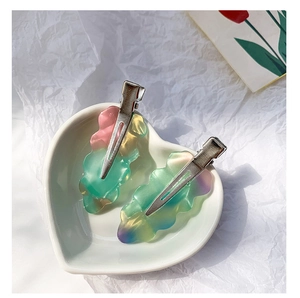 Macro shot of colorful gradient wave hair clips in acetate resin on white heart ceramic dish