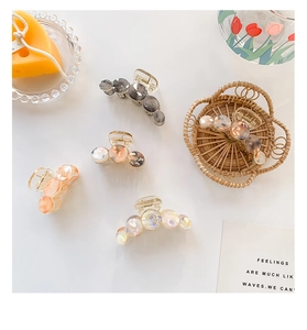 Detailed top view of five elegant floral pattern hair claws on a clean white background