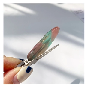Detail of pink and green marbled resin hair clip with silver metal alligator clip